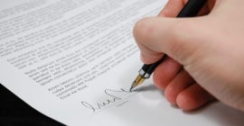 Someone signing their name on a document